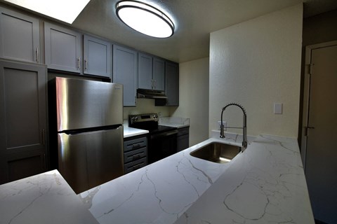 a kitchen with stainless steel appliances and white marble counter tops